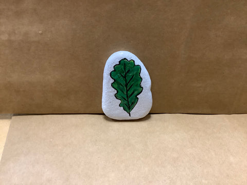Hand painted rock of green leaf with white background by local artist Cecelia each