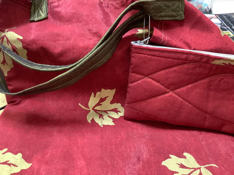 Tote bag with gold leaves on Reddish Burgandy silky material. Has a extra handy small tote with zipper. By artist Carol.