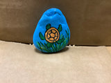 Turtle in grass  hand painted by local artist Cecelia.  Each rock is $3.