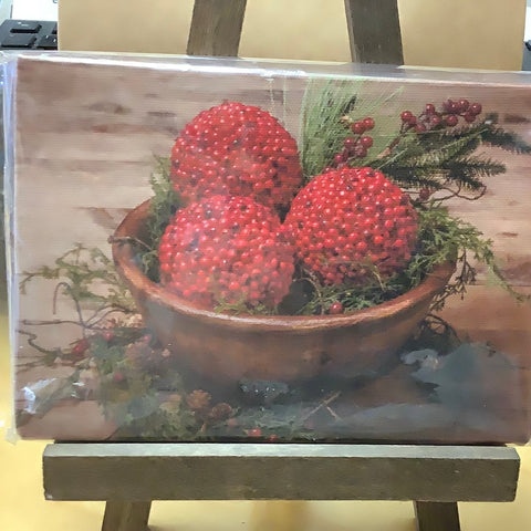 Red currant balls with greens and berries in wooden bowl on  a wooden frame.