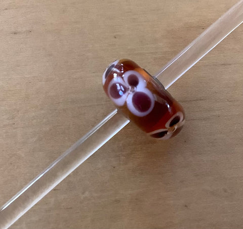 Unique Trollbead amber w/ mauve and white flower